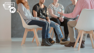 men and women sitting in a circle receiving group therapy